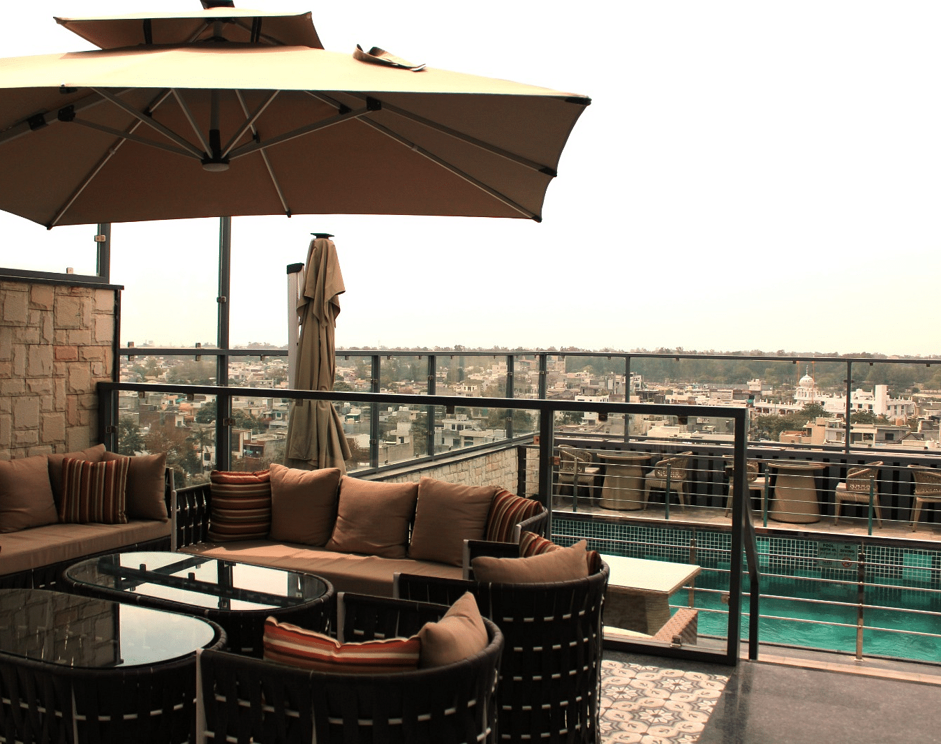 A rooftop lounge with a spacious patio and an adjacent swimming pool at BluSalzz Residence, Amritsar